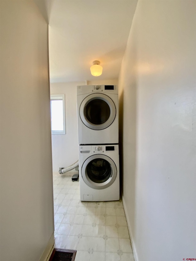 clothes washing area featuring stacked washer / drying machine