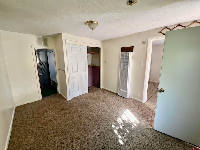 unfurnished bedroom featuring carpet floors, a textured ceiling, and a closet