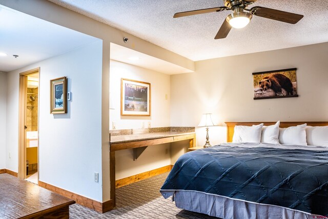 carpeted bedroom with connected bathroom, baseboards, and a textured ceiling