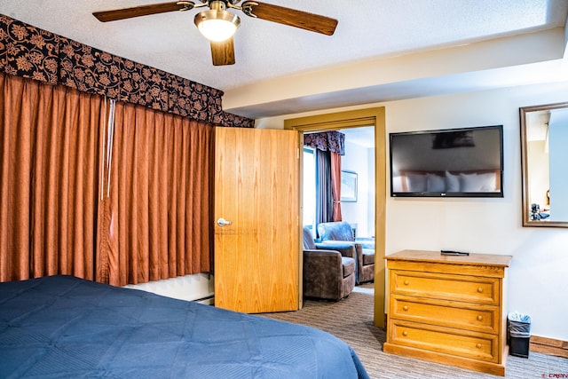 bedroom with ceiling fan, carpet flooring, and a textured ceiling