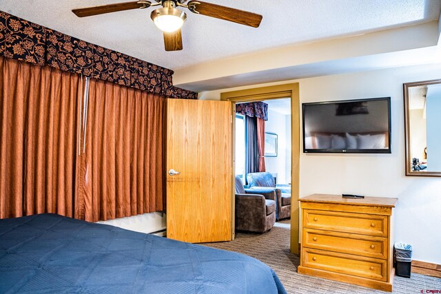 bedroom with carpet flooring, a textured ceiling, and a ceiling fan