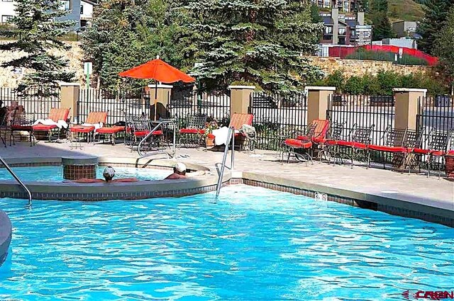 view of pool featuring a patio and fence