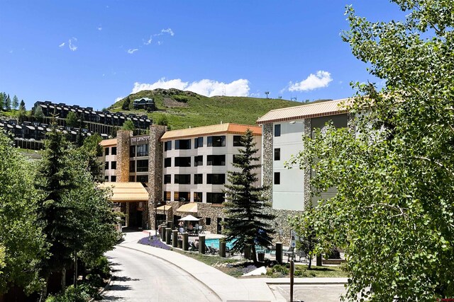 view of building exterior featuring an outdoor pool and a mountain view