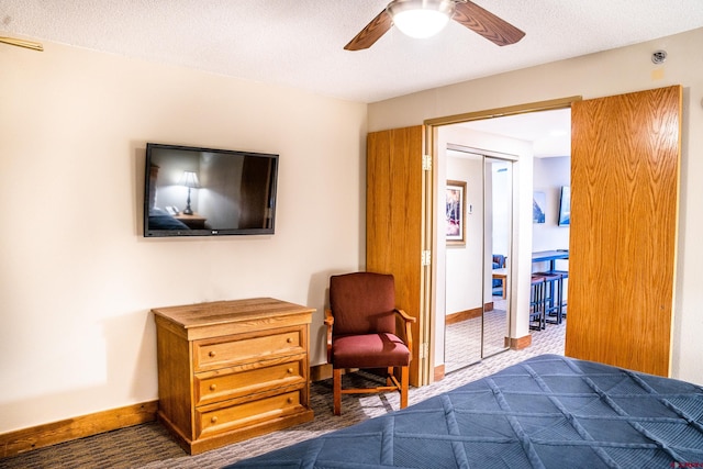 carpeted bedroom with a textured ceiling, a closet, and ceiling fan