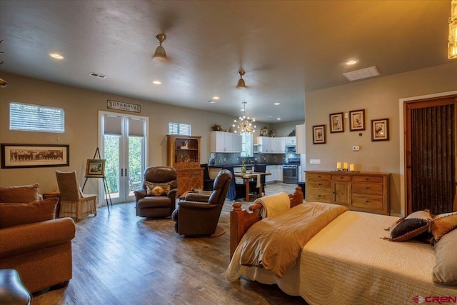 bedroom with an inviting chandelier, access to outside, dark hardwood / wood-style floors, and french doors