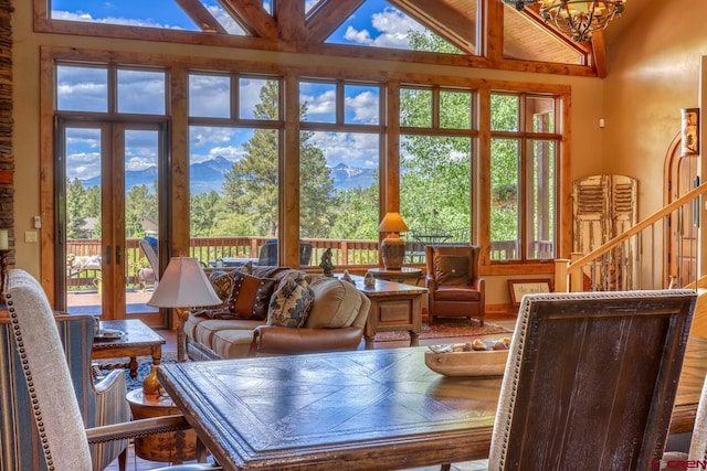 living room featuring hardwood / wood-style flooring, a chandelier, and high vaulted ceiling