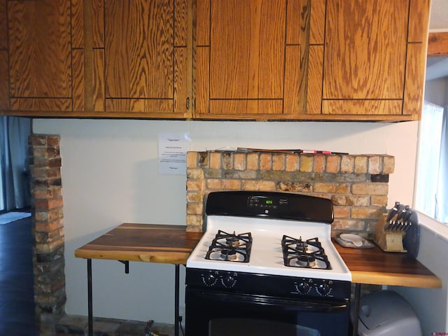 kitchen with white gas stove and a fireplace