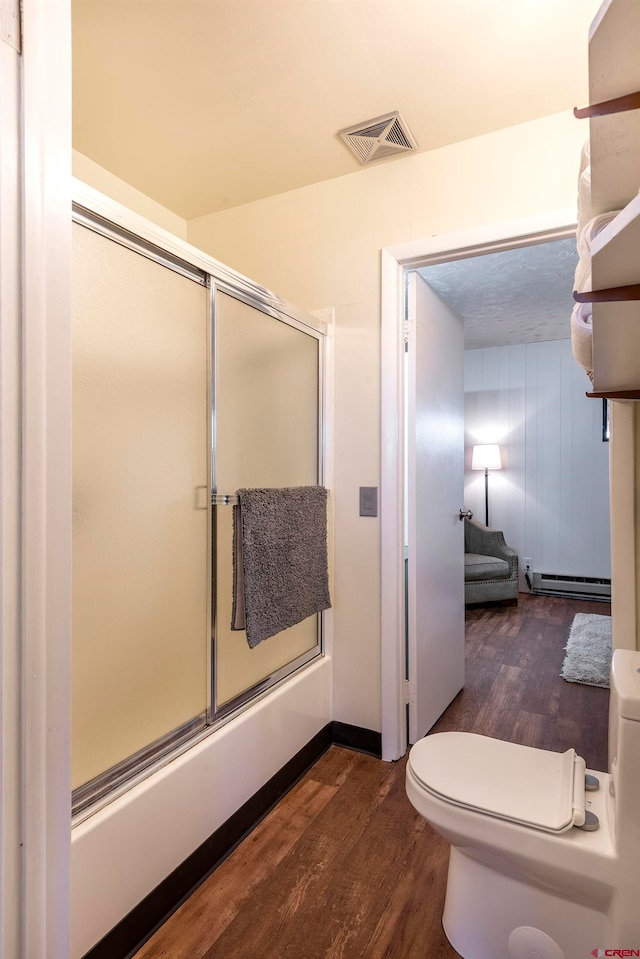 bathroom featuring baseboard heating, toilet, and wood-type flooring