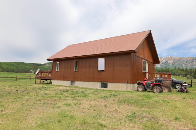 view of side of home featuring a mountain view and a yard