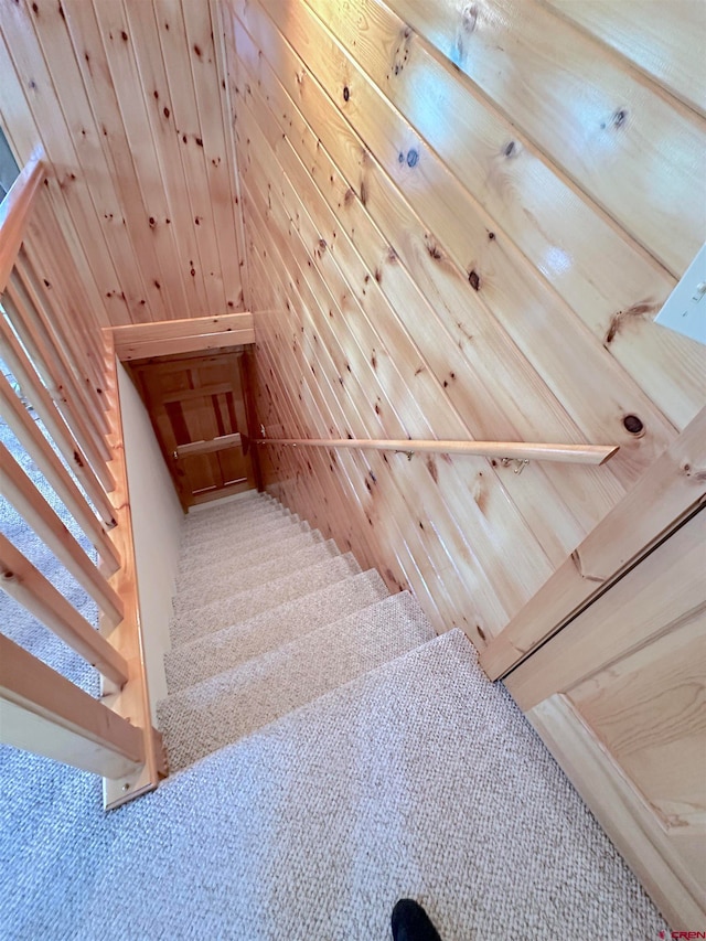 stairs with wood walls and carpet