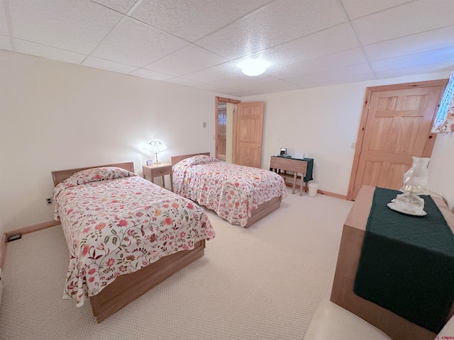 bedroom featuring carpet floors and a drop ceiling