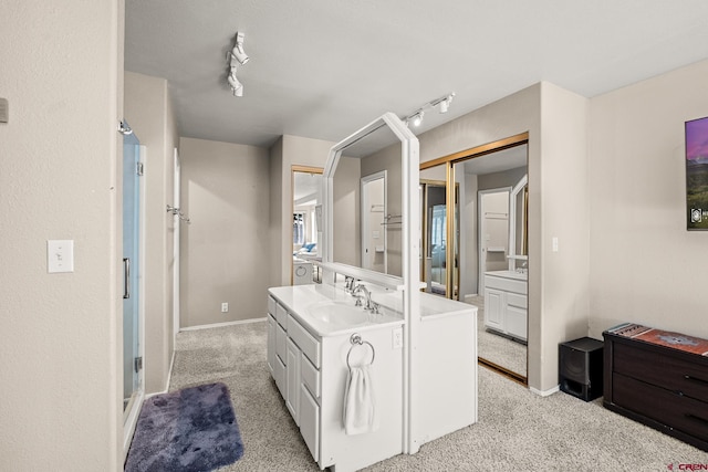 full bath featuring baseboards, carpet flooring, vanity, and track lighting