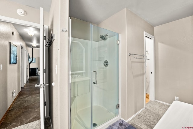 full bathroom featuring a shower stall and baseboards