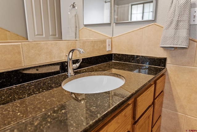 bathroom featuring tasteful backsplash, tile walls, and vanity