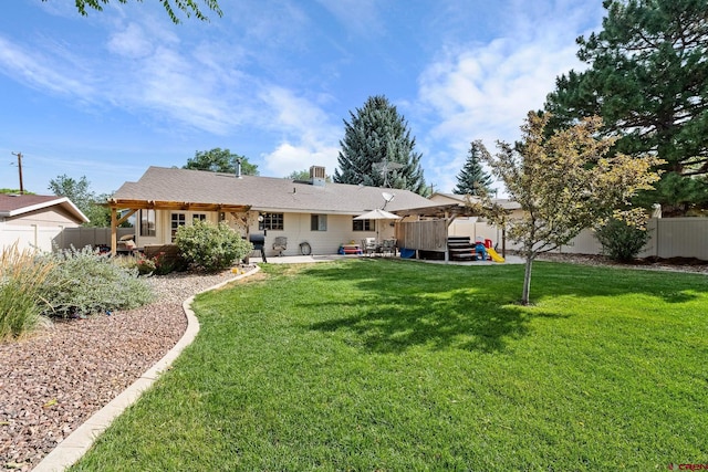 rear view of property featuring a lawn, a patio area, and a fenced backyard