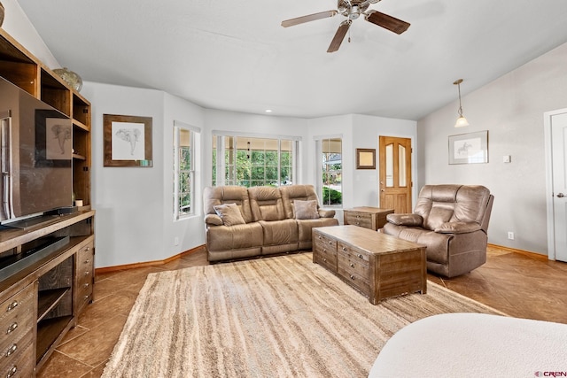 living room with lofted ceiling, tile patterned flooring, baseboards, and ceiling fan