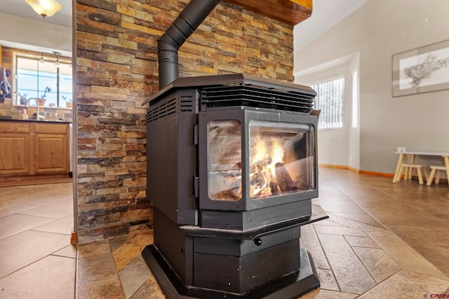 interior details with a sink, a wood stove, and baseboards