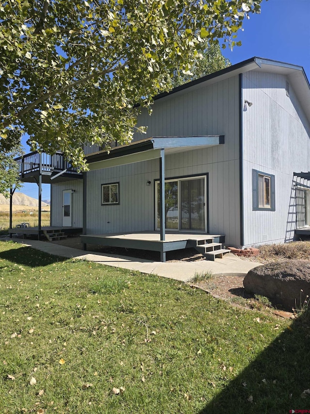 rear view of property with a deck and a lawn