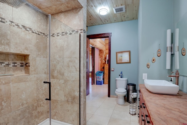 bathroom with tile patterned floors, vanity, an enclosed shower, and toilet