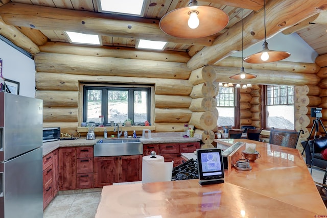 kitchen featuring light tile patterned flooring, stainless steel refrigerator with ice dispenser, lofted ceiling with skylight, sink, and log walls