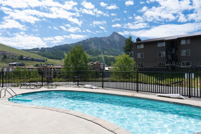 view of swimming pool with a mountain view