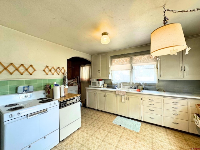 kitchen with tasteful backsplash, pendant lighting, a textured ceiling, and white appliances