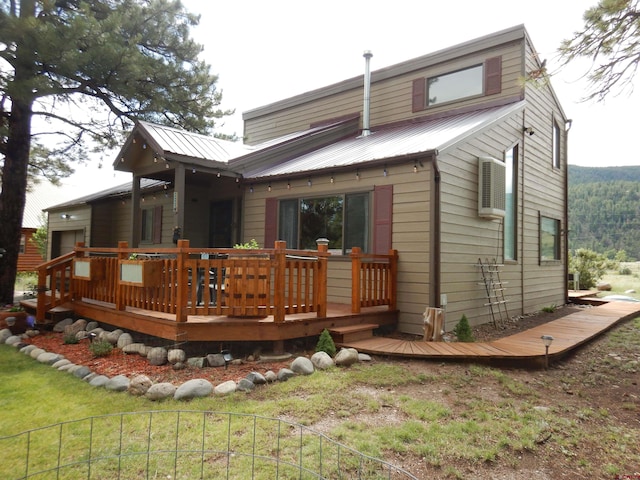 rear view of house featuring a wooden deck and a yard