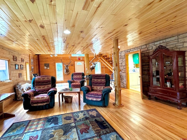 living room with wood walls, a wealth of natural light, and light hardwood / wood-style floors