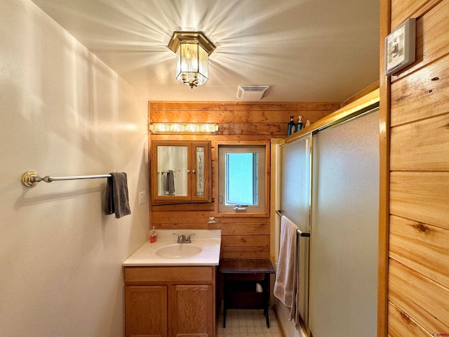 bathroom featuring vanity, wooden walls, and tile patterned flooring