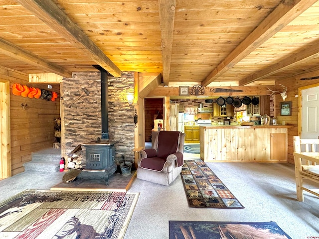 unfurnished living room with a wood stove, wooden ceiling, light carpet, and beamed ceiling