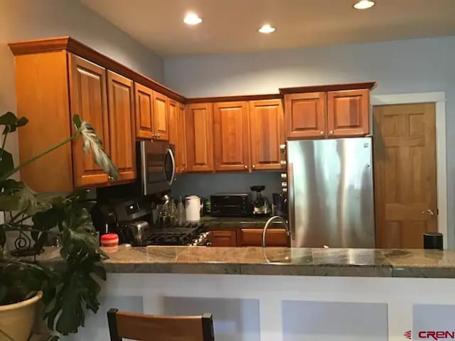 kitchen with kitchen peninsula, stainless steel appliances, and sink