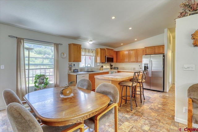 dining room with lofted ceiling, stone finish flooring, recessed lighting, and baseboards