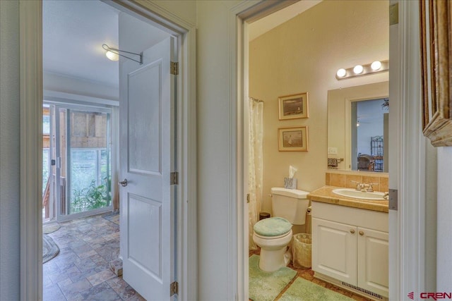 full bathroom with stone finish floor, visible vents, vanity, and toilet