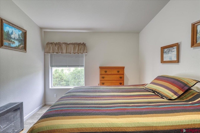 bedroom with baseboards and light colored carpet