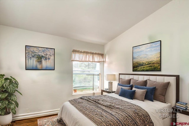 bedroom with baseboards, vaulted ceiling, and wood finished floors