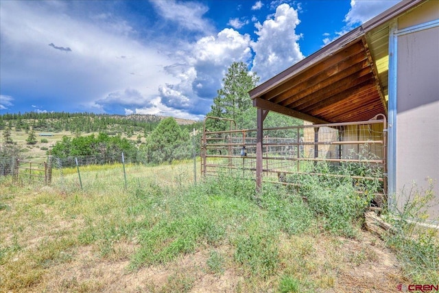 view of yard with a rural view, an outdoor structure, and an exterior structure