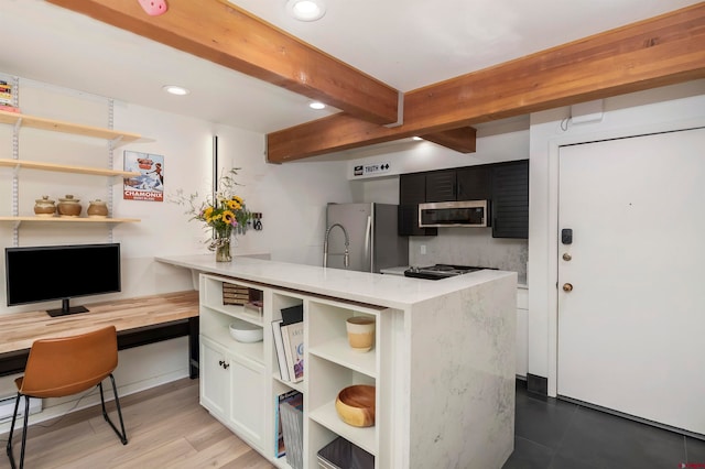 kitchen with kitchen peninsula, appliances with stainless steel finishes, light wood-type flooring, beamed ceiling, and white cabinets