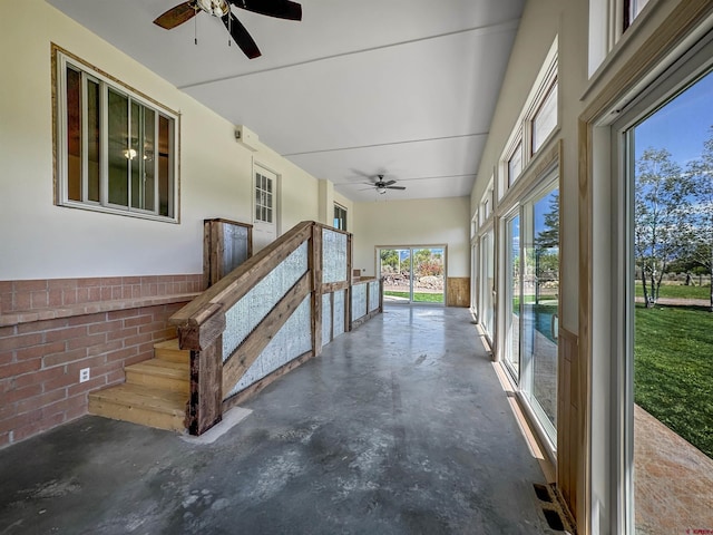 unfurnished sunroom featuring ceiling fan