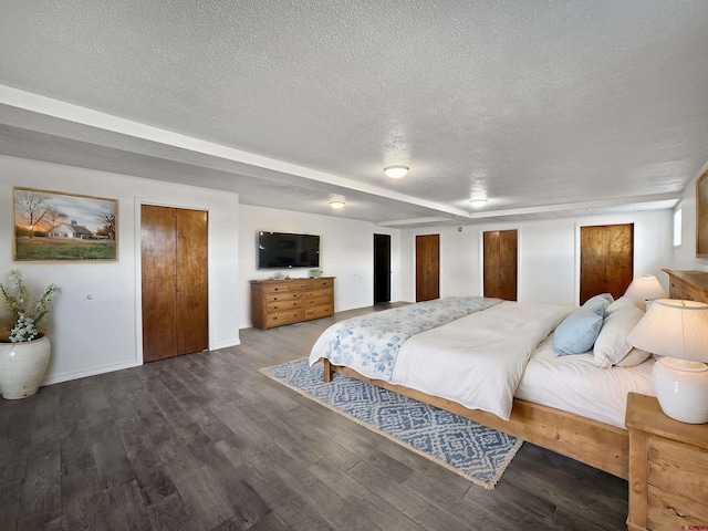 bedroom with a textured ceiling, wood finished floors, and baseboards