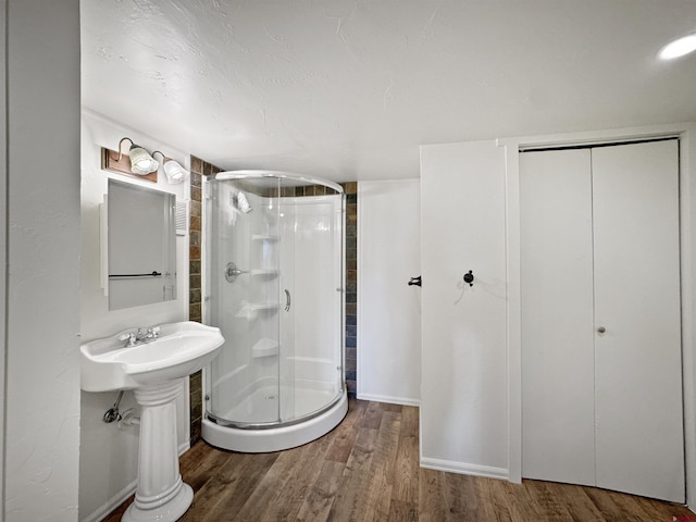 bathroom featuring a stall shower and wood finished floors