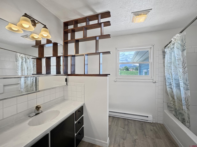 bathroom with a textured ceiling, a baseboard radiator, shower / bath combo with shower curtain, hardwood / wood-style flooring, and vanity