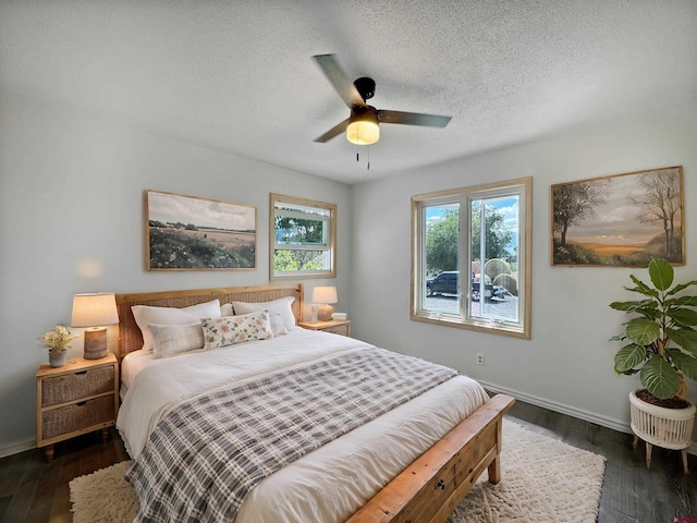 bedroom featuring ceiling fan, a textured ceiling, baseboards, and dark wood-style flooring