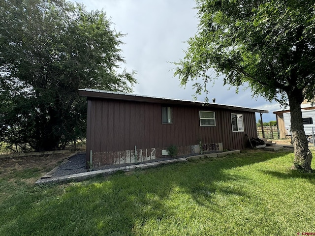 view of property exterior featuring board and batten siding and a yard