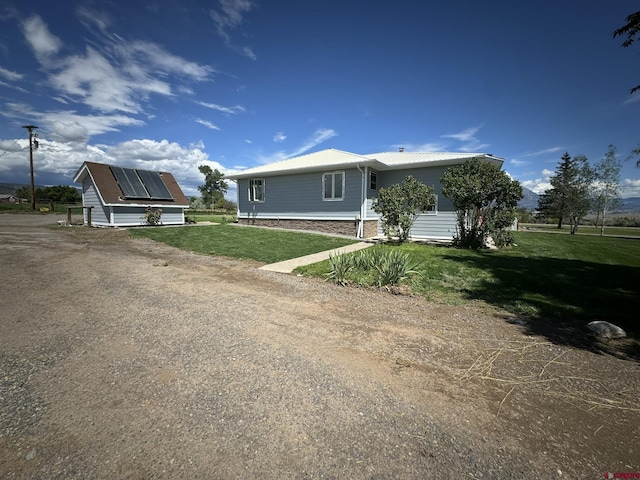 view of front facade with a front yard and metal roof