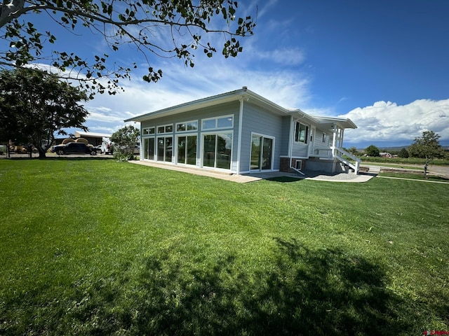 rear view of property with a lawn