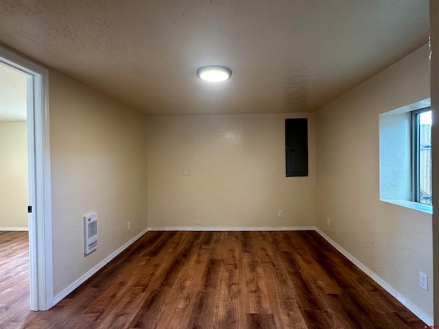 spare room featuring electric panel and hardwood / wood-style flooring