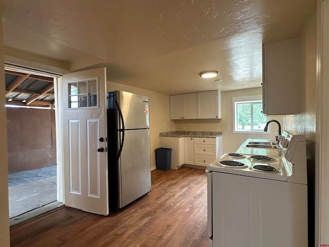 kitchen with white electric stove, wood-type flooring, sink, white cabinetry, and stainless steel fridge