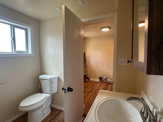 bathroom featuring sink, toilet, and hardwood / wood-style floors