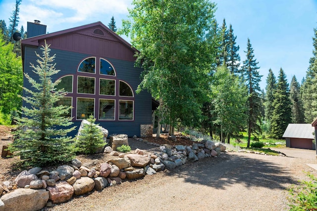 view of side of property with driveway and a chimney