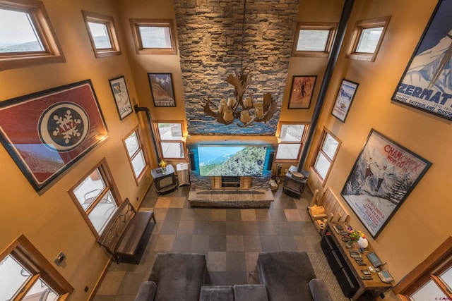 living room featuring a wealth of natural light, a high ceiling, and dark tile patterned floors